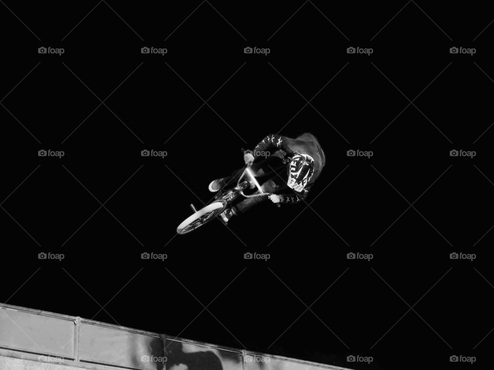 Black and white, bmx biker on a vertical ramp. Radical sports photo, airtime, airborne bmx.