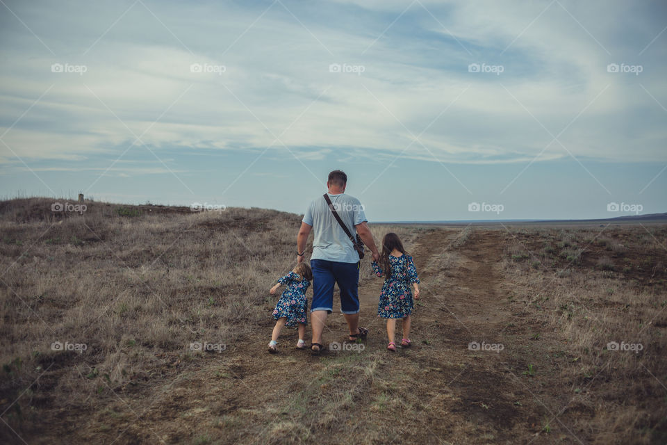 Father with two daughters walking outdoor 