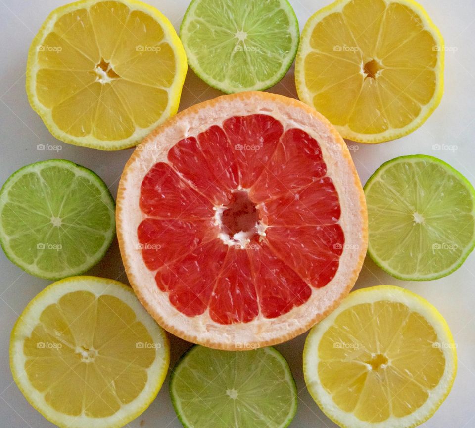 Flat Lay of grapefruit, lime and lemon halves on white background
