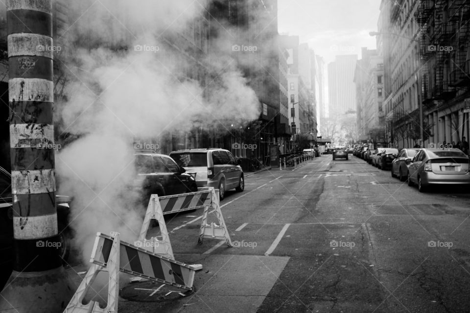 Steam rises from a manhole in downtown Manhattan.