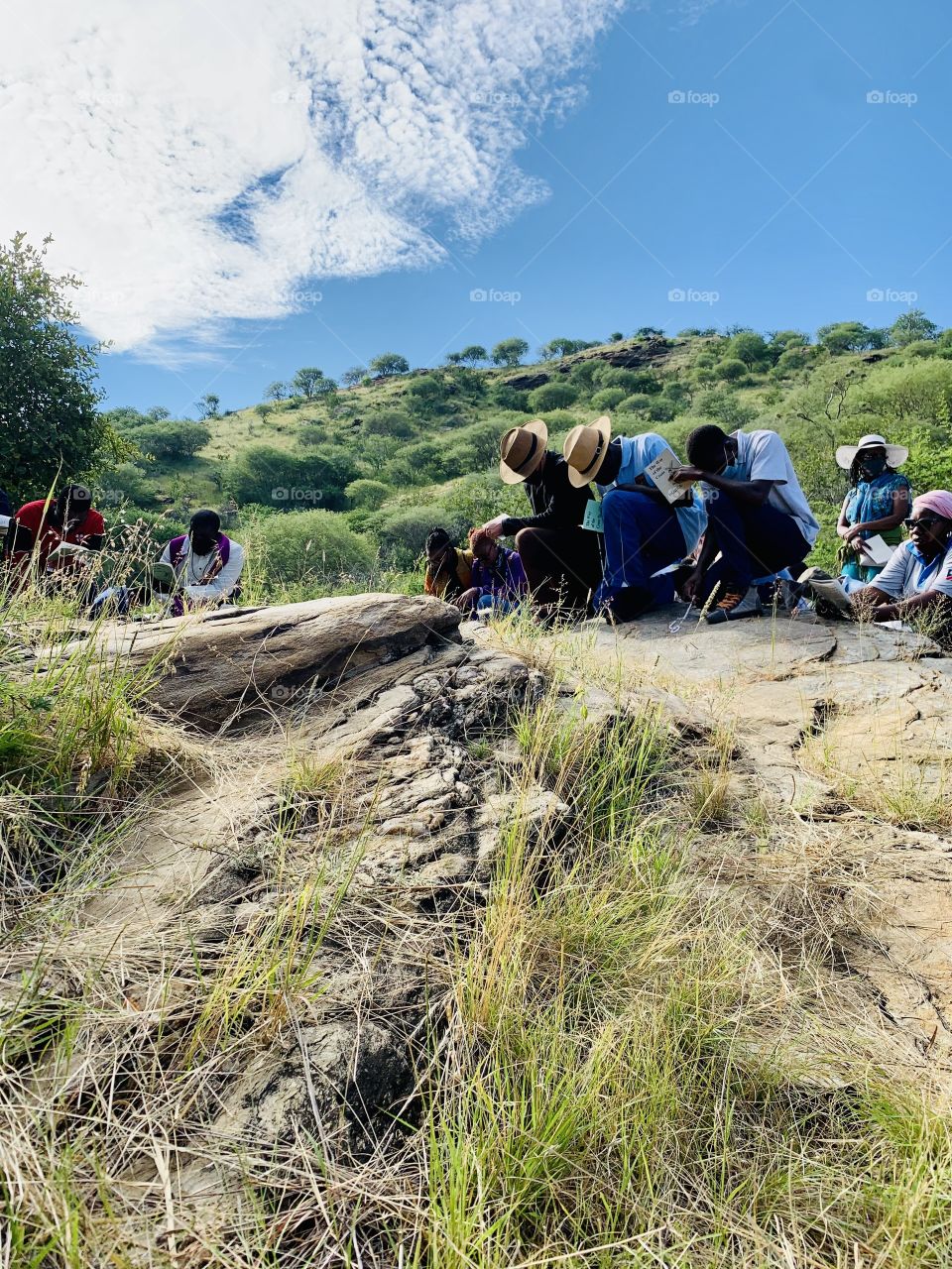 A group of people kneeling and bowing down on a prayerful pilgrimage on a rock on the mountains. 