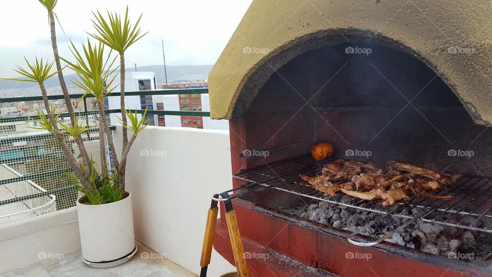 Barbecue at the balcony on a rainy day .
