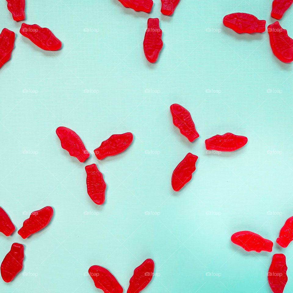 Bright red tri fish pattern on turquoise background 