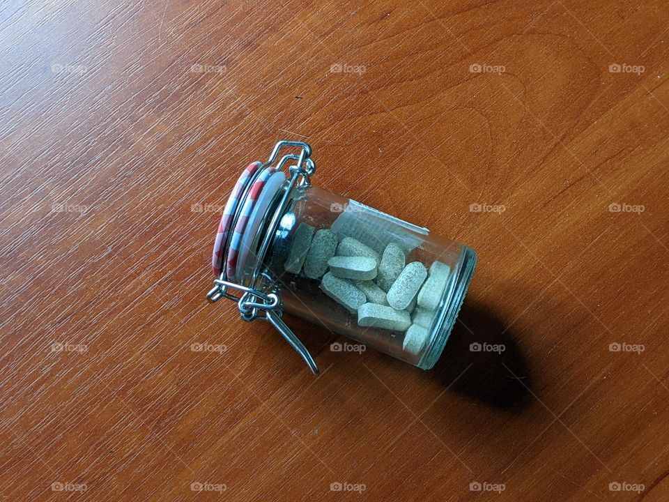 vitamins in a small jar on the table