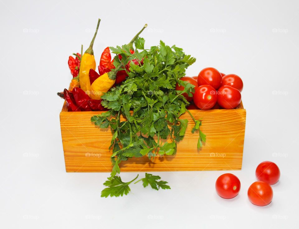 Mandatory ingredients of every kitchen : cherry tomatoes, hot peppers and parsley in a wooden box