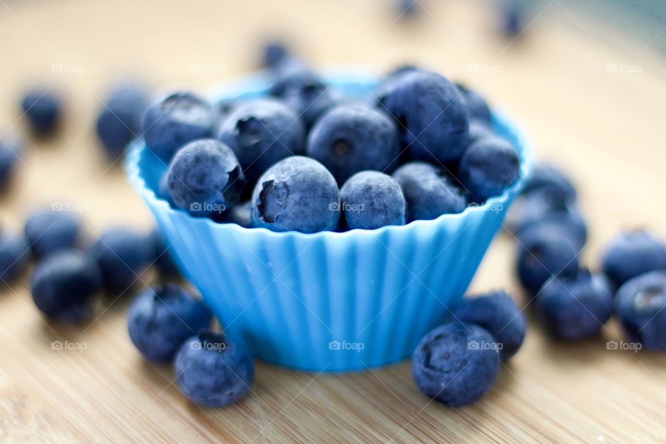 Fruits! - Blueberries In blue silicone baking cups on bamboo surface