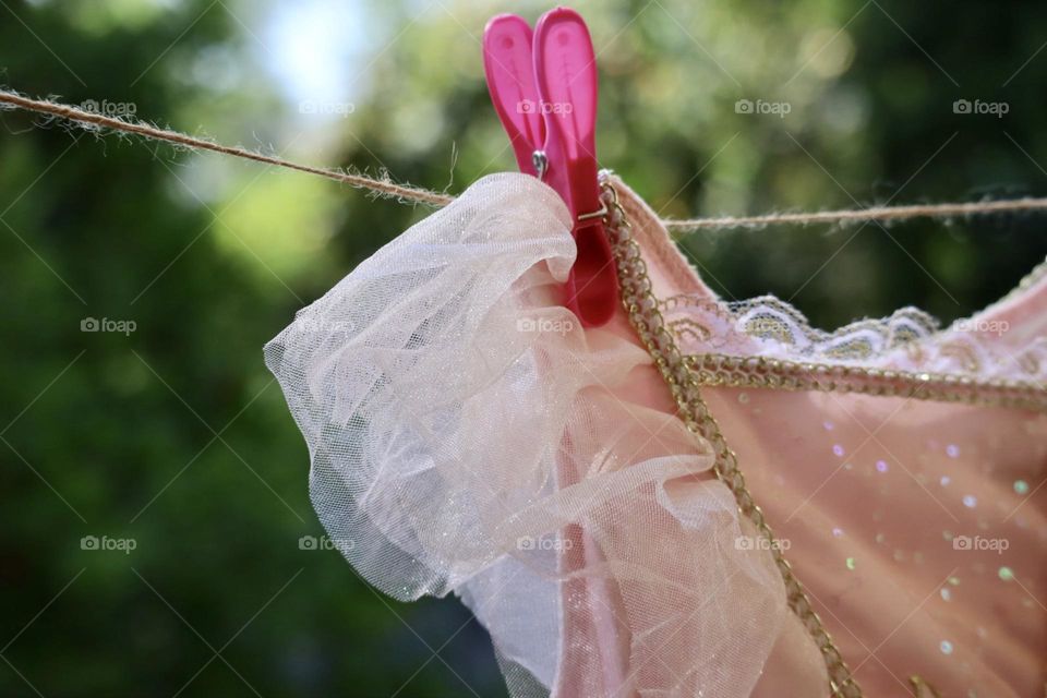 Pink princess dress hanging with pink clothespin 