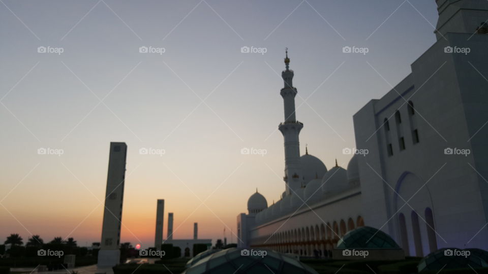 Huge and beautiful mosque near Dubai at the sunset. Red sun.