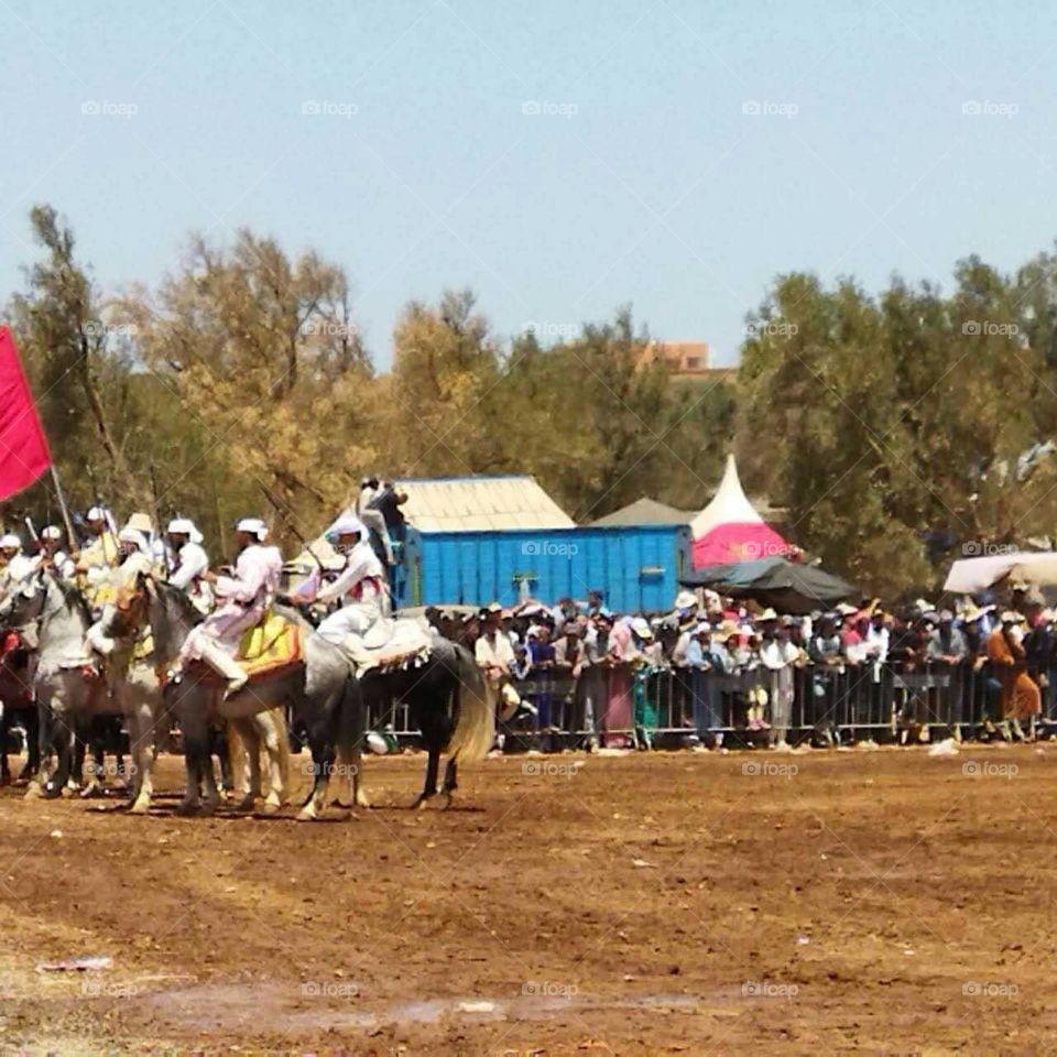 Crowd of people watching the  race of  horses.