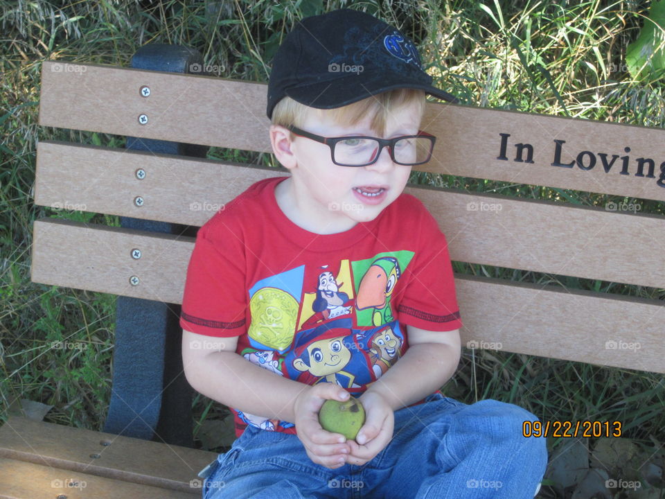 Close-up of cute boy sitting on bench