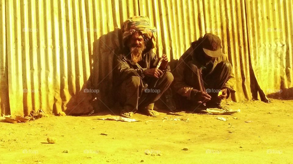 This dude was rolling a massive joint in a newspaper and him and his sadhu pal will smoke it for a long time ...