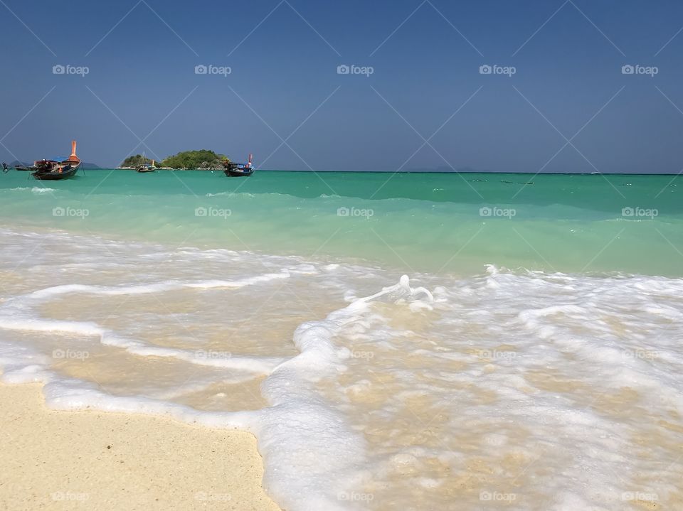 Splashing sea waves on sand beach 