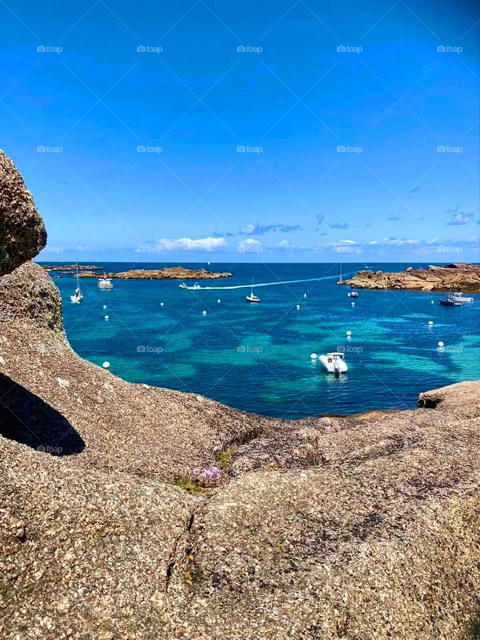 View of the sea and the boats through the rocks in Trégastel