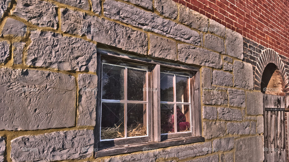 Barn window and door. barn cats have bedding in windows of historic old stone barn