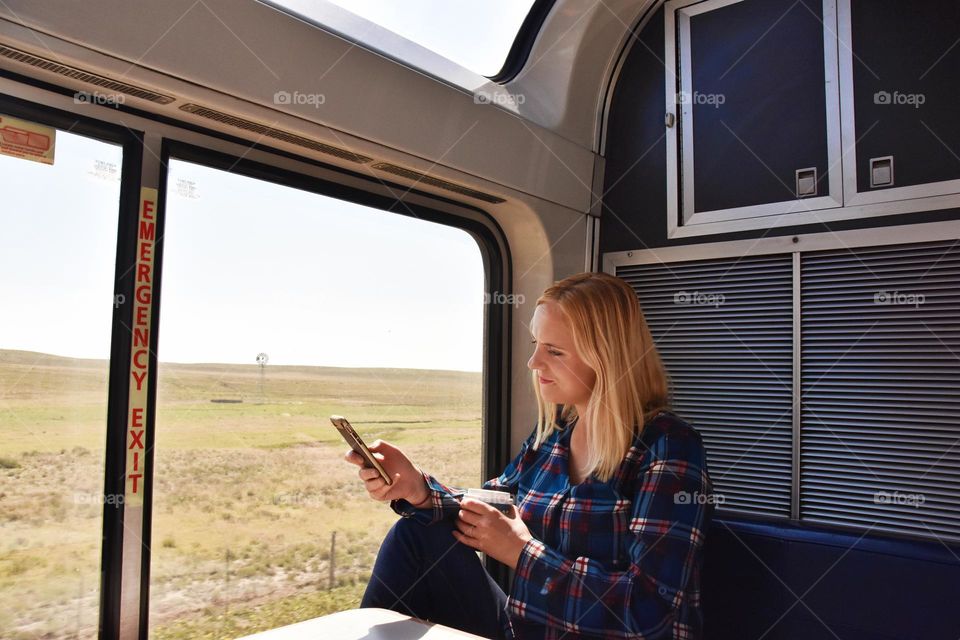 Woman going by train across USA and using mobile phone