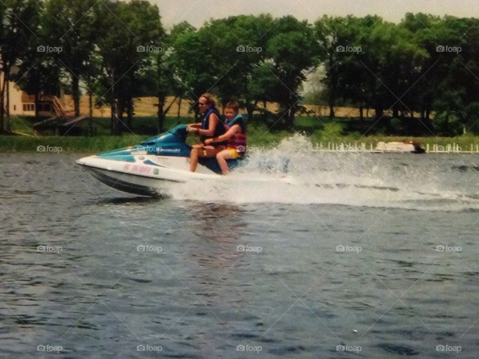 Woman and boy on jet ski on lake