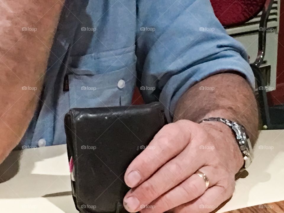 Man at restaurant table with wallet in hand to pay bill