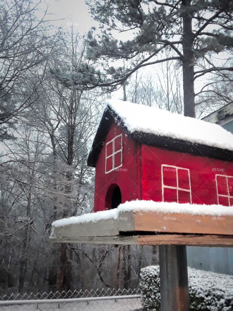 snow on red homemade bird house