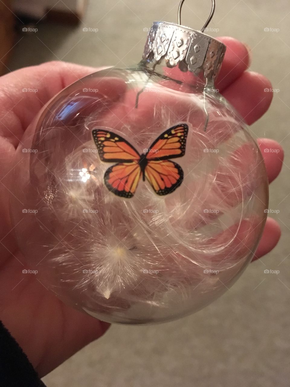 Hand holding glass glove butterfly fly ornament