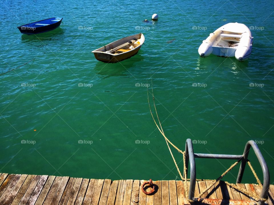 Three boats moored to a wooden dock