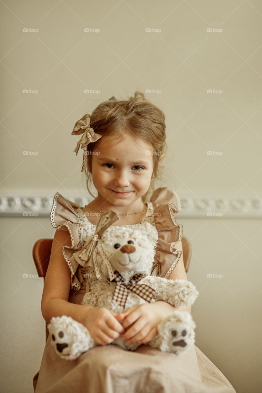 Vintage portrait of a beautiful little girl with teddy bear 