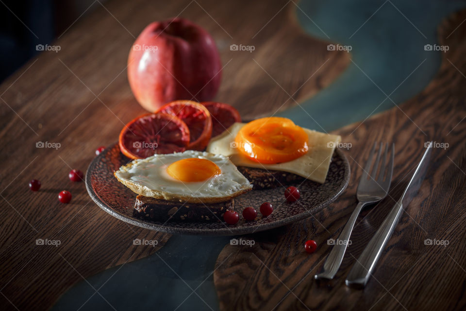 Sandwiches with fried egg orange tomato and red orange fruit 