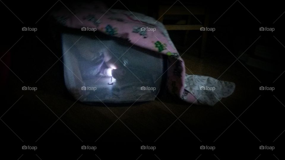 Tent. My toddler is playing in a makeshift tent of mesh laundry basket and a blanket.