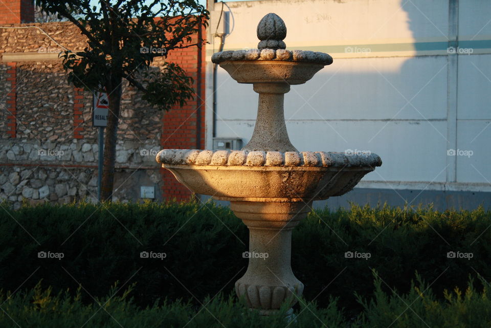 Small stone fountain in the light of sunset.