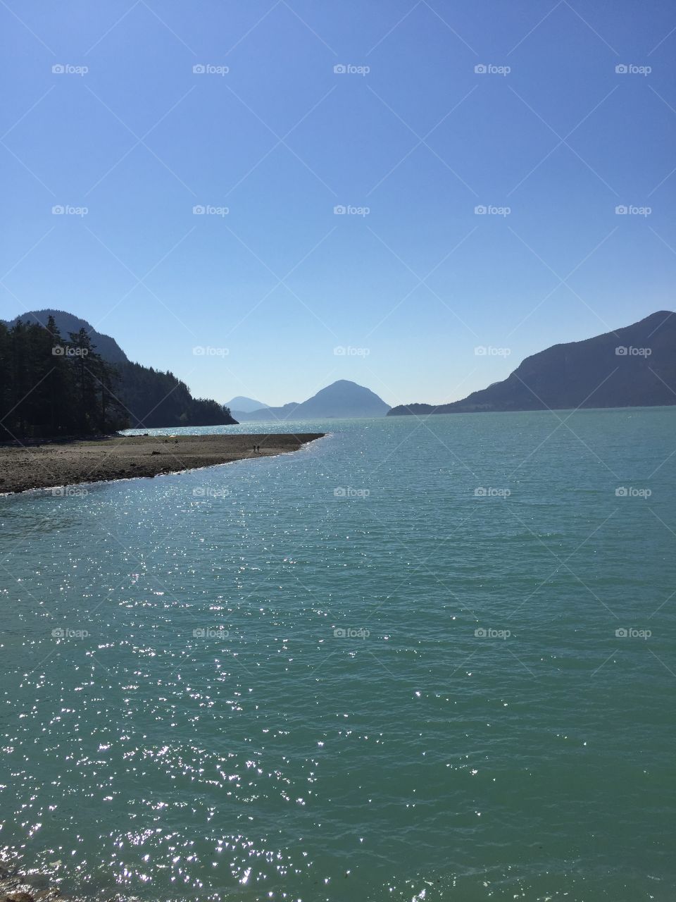 View south of Porteau Cove of Howe Sound with a calm ocean and clear blue skies.