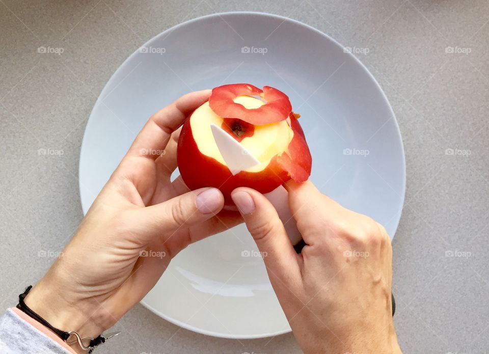 Directly above view of person peeling apple