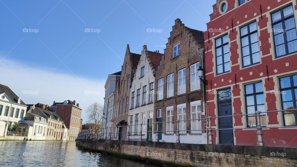 Beautiful view of medieval beautiful and historic houses of the sixteenth century on the canal in the city of Bruges in Belgium on a sunny day, close-up side view.