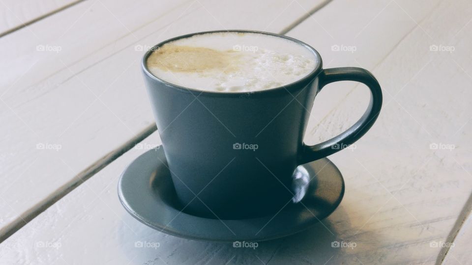 Vintage cup of coffee on a white wooden table