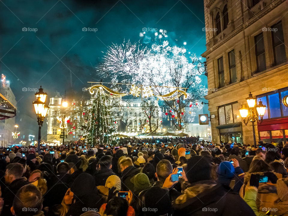 People Enjoying Holidays Taking Photos With Cellphones At New Years Eve Celebration Outdoor Crowded Party With Fireworks
