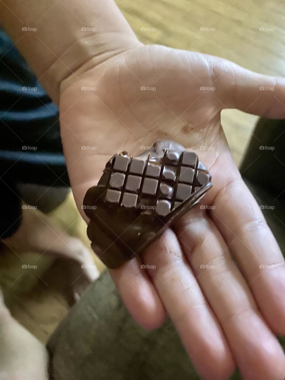 Homemade Chocolate Squares candy bar in hand look like a flattened Rubiks cube. 