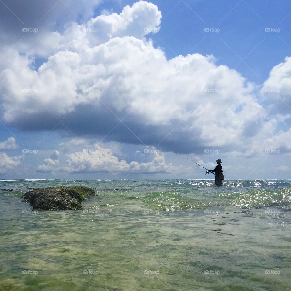 Fisherman standing in the ocean