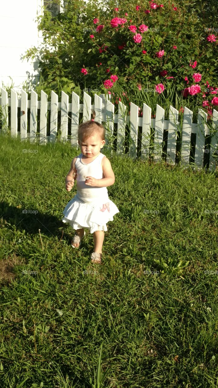 Cute little girl standing in garden
