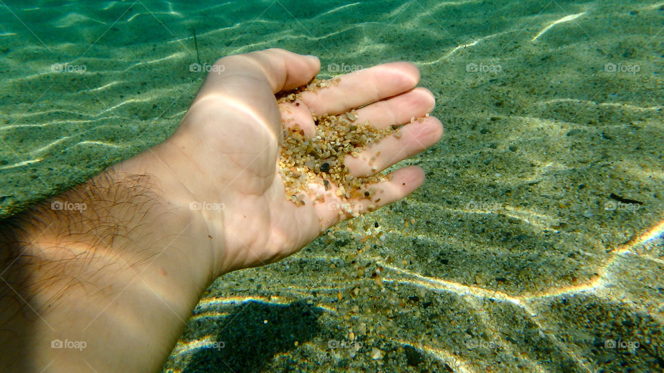 man with sand in his hand underwater