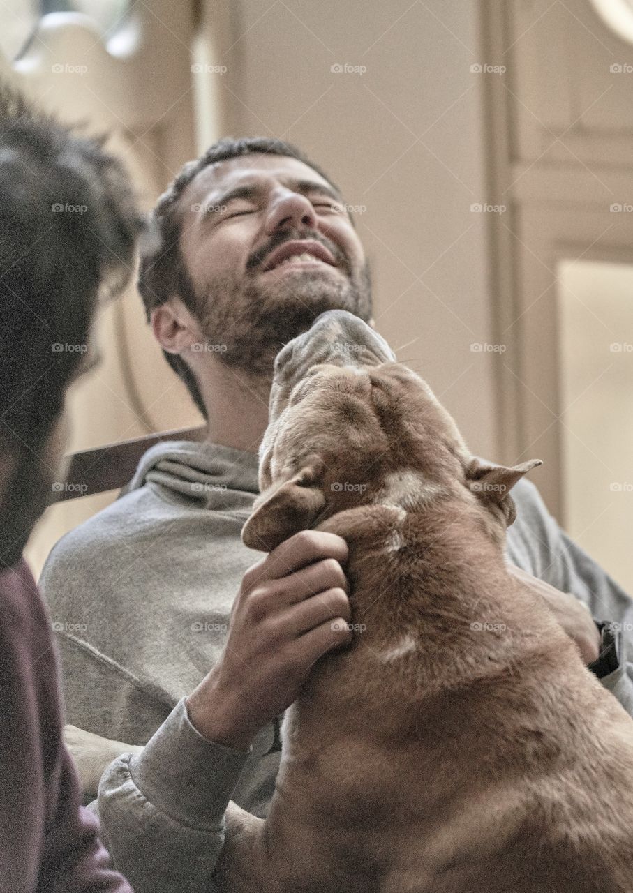 Dog licking on the man's neck