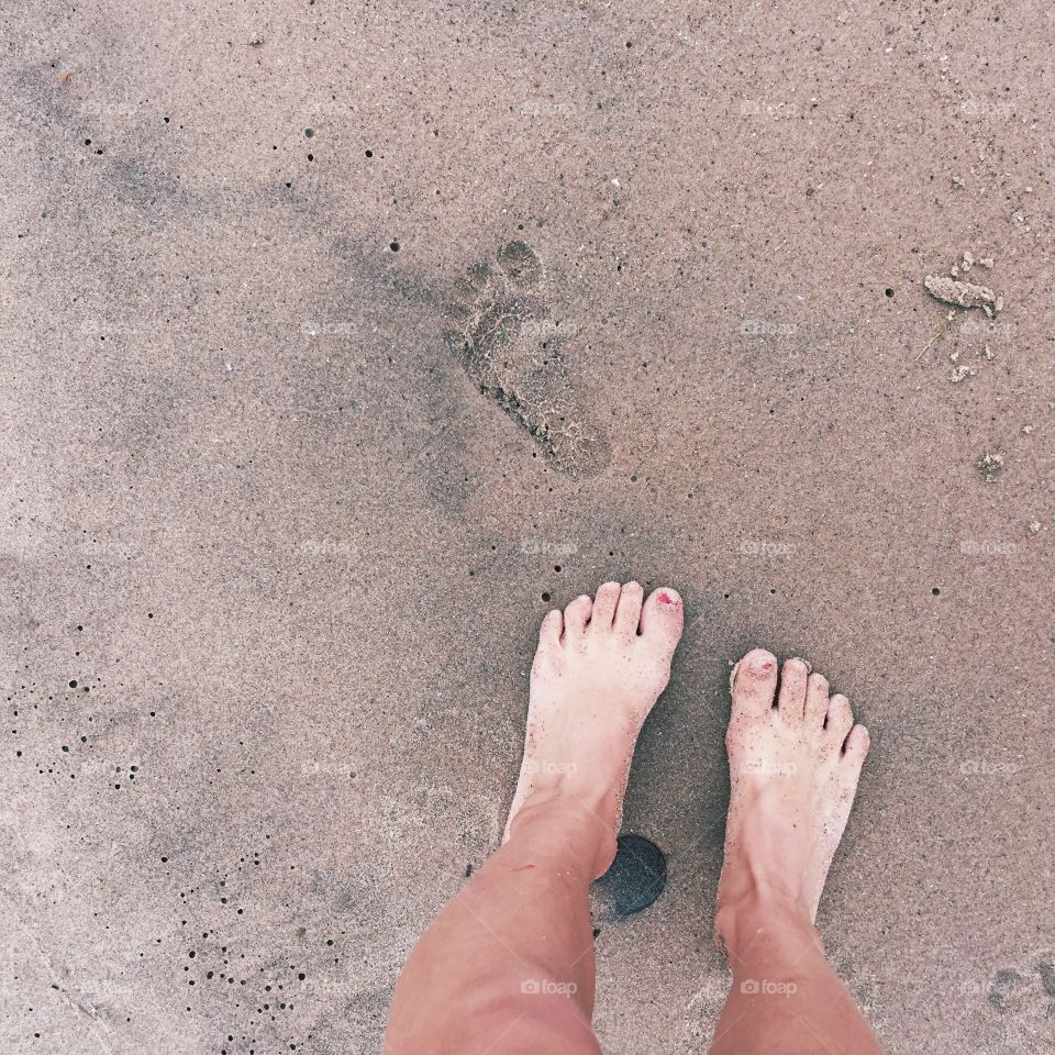 Midsection of barefoot on beach