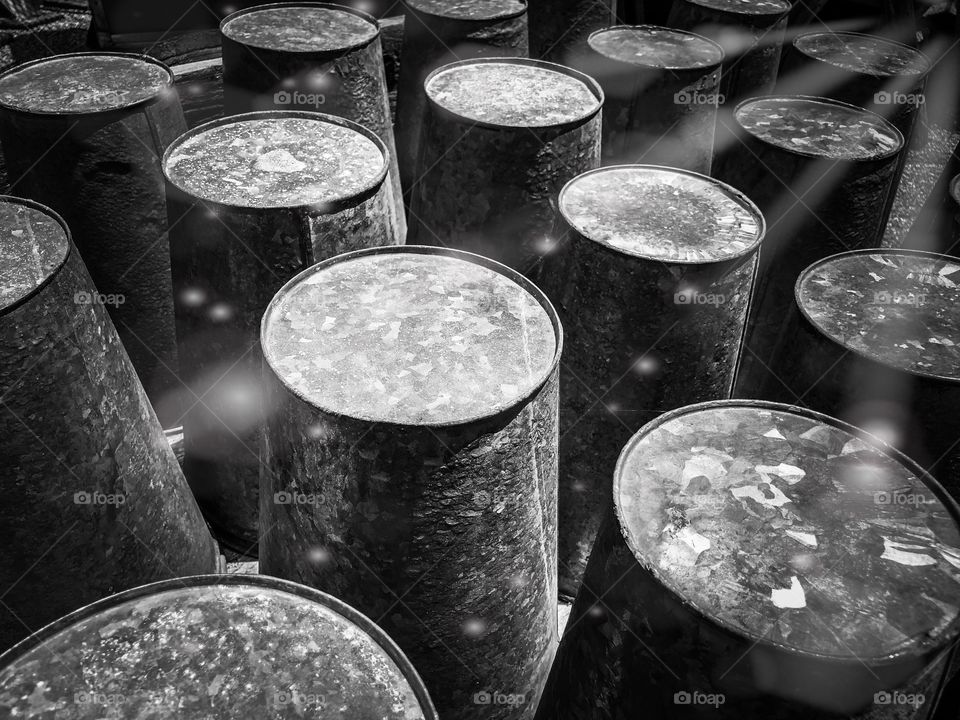 Galvanized metal pails arranged in symmetrical rows with a light leak filter