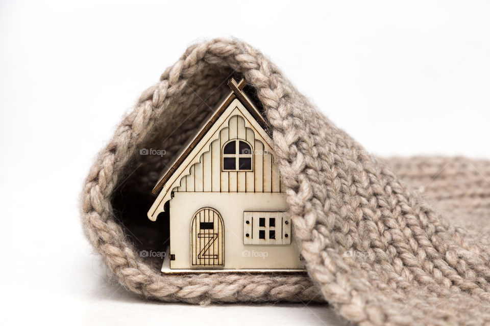 toy wooden house wrapping in warm knitting scarf