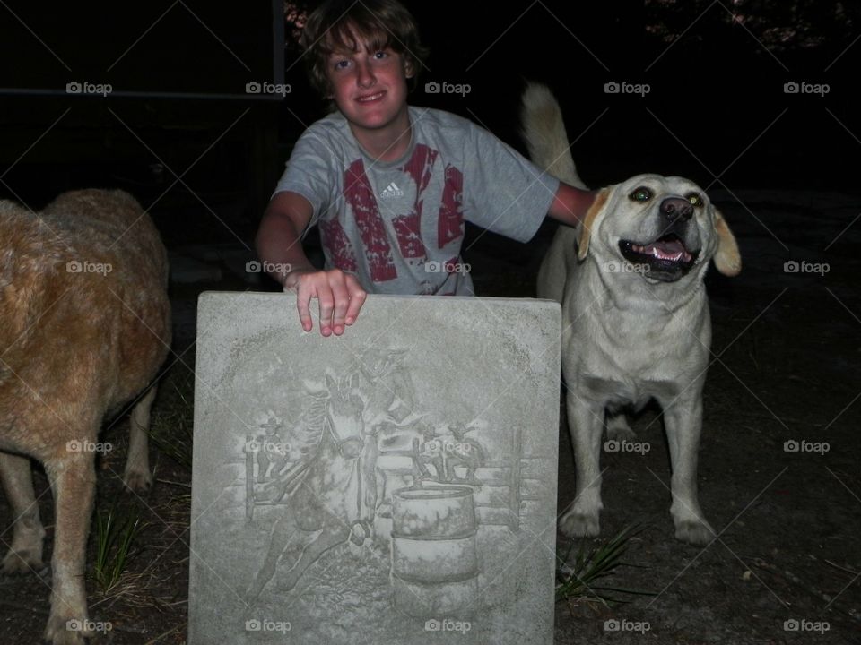 A boy and his dogs showing a home made stepping stone