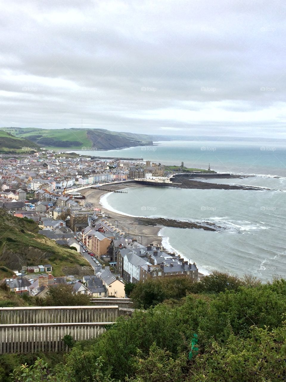 View of a sea town from the top of the hill. I can see the beach from up here. Looks like rain. 