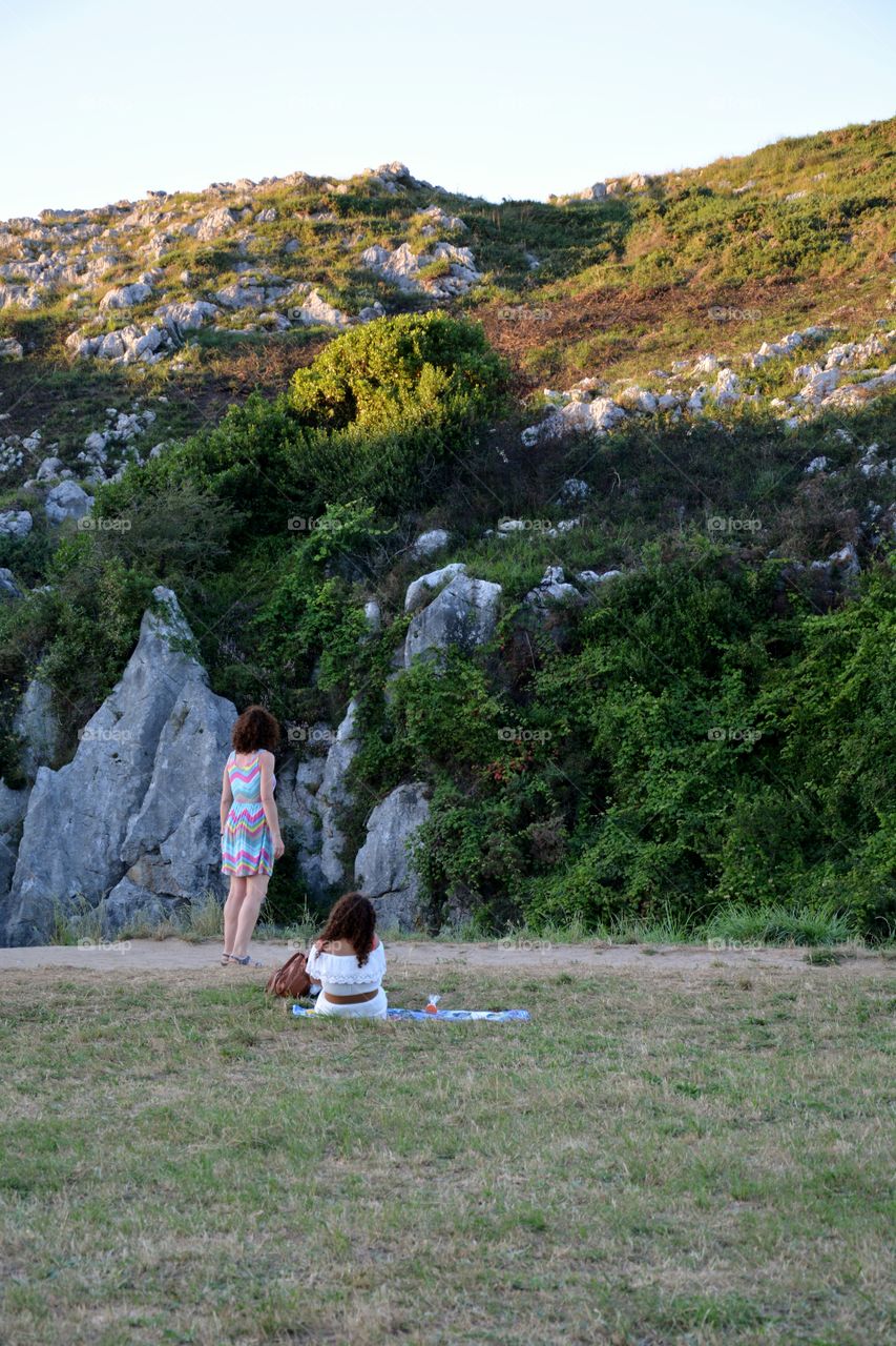 two women watching the sunset in the nature