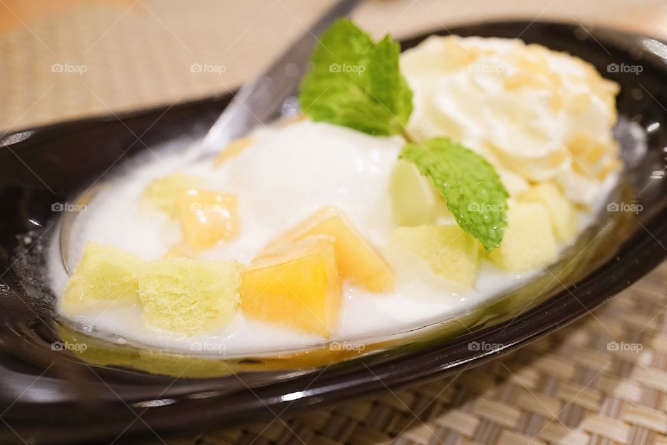 Mango dessert with coconut milk ice cream and whipping cream.