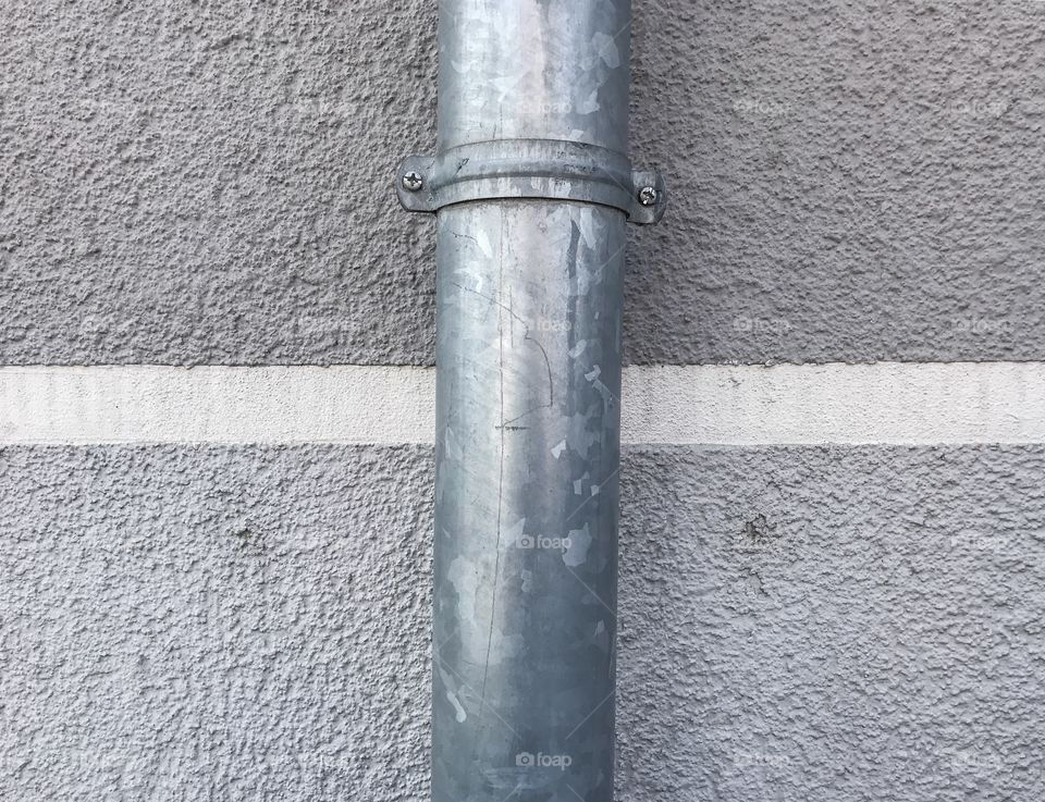 Rain pipe on striped wall
