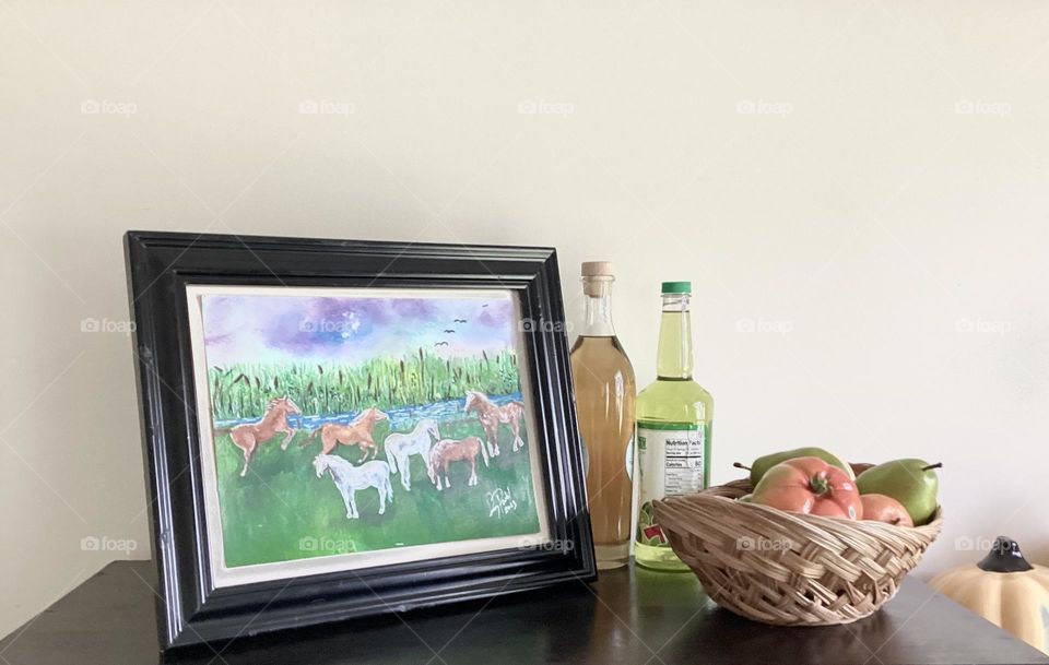 Marco de foto con caballos en la pradera y botellas de licor y una cesta dará un toque íntimo de libertad y amor por el hogar .