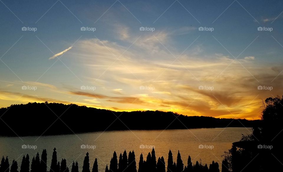 sun setting on lake with yellow hue