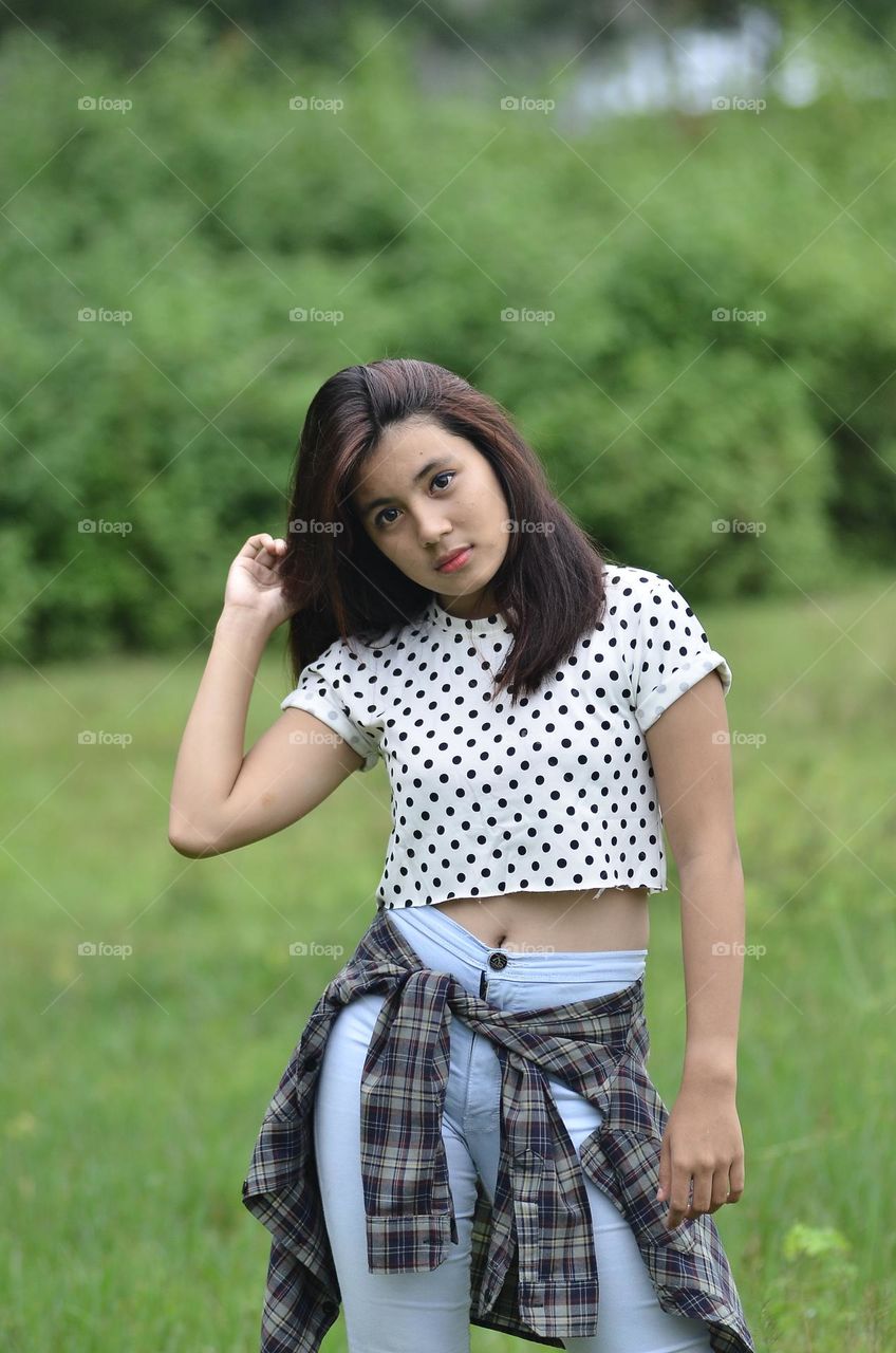 a beautiful girl is posing in casual clothes