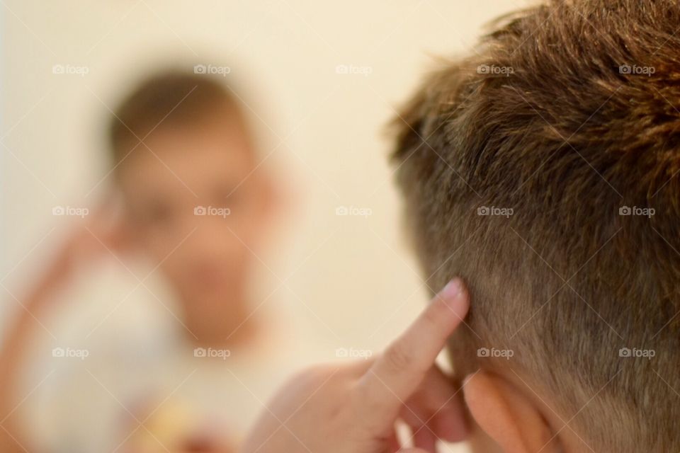 A kid looking at the mirror 